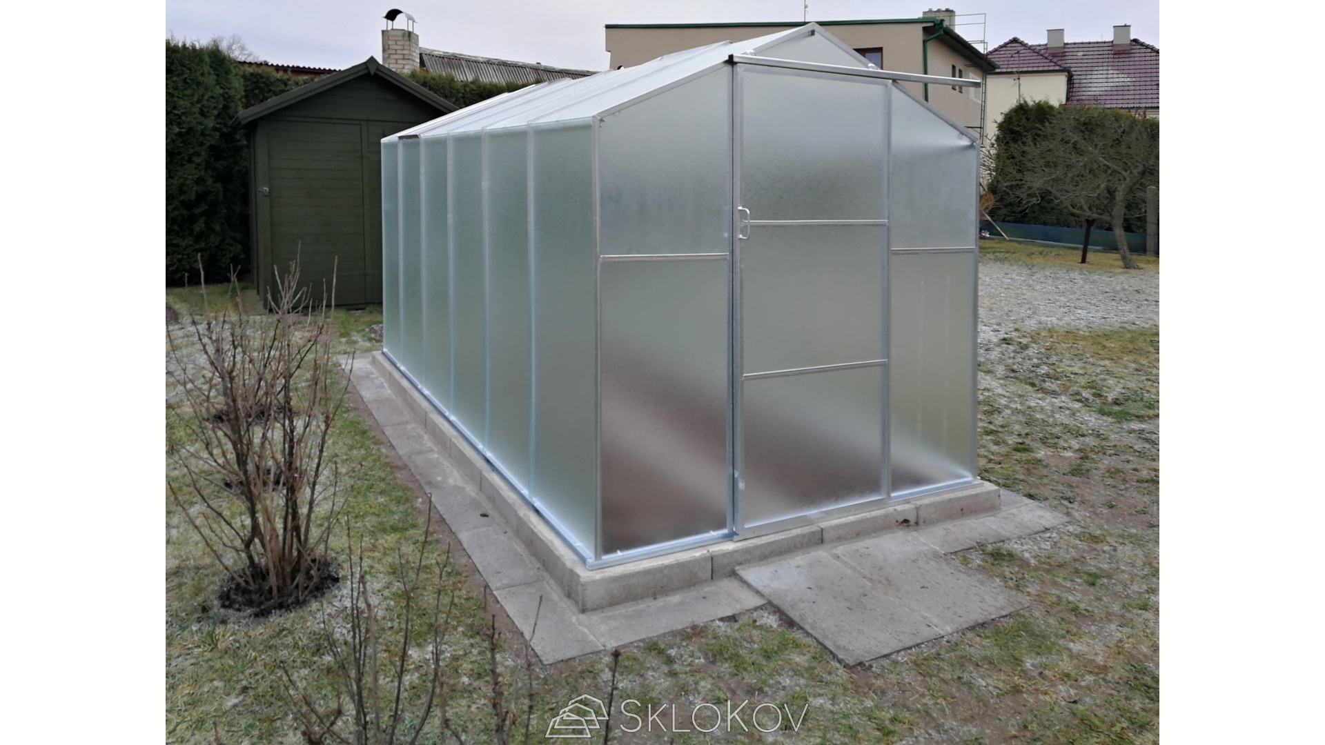 Je vhodné zpevnit plochu před skleníkem alespoň na šířku dveří.